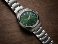The Laureate — steel round watch with green sunburst dial and gold hands